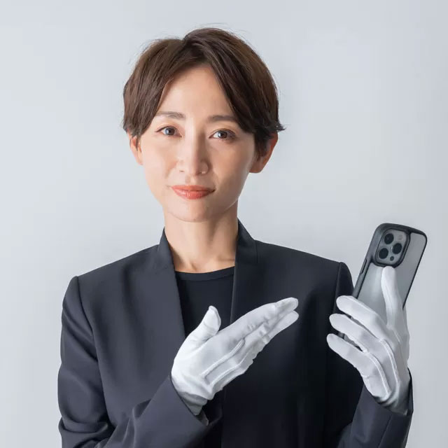 白い手袋をしたスーツの女性が手でアイフォンを指し、案内している