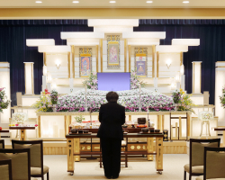 祭壇に一礼しているスーツを着た女性