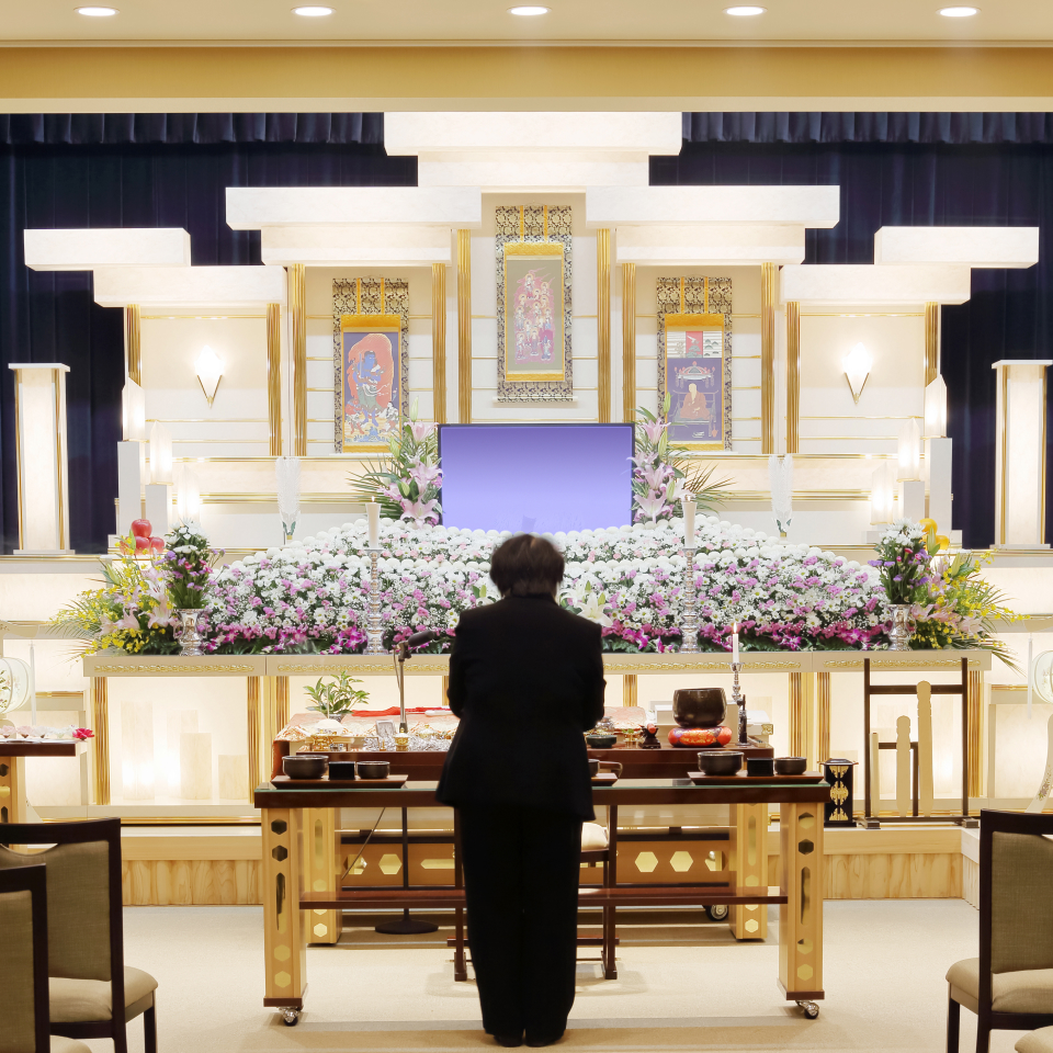 祭壇に一礼しているスーツを着た女性