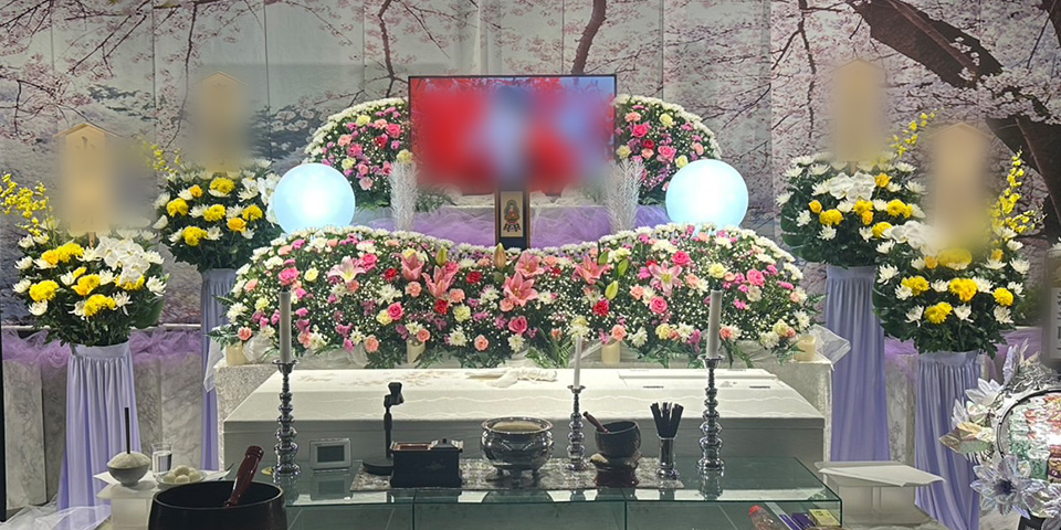 桜の屏風を背景にピンクと黄色を基調とした花の祭壇