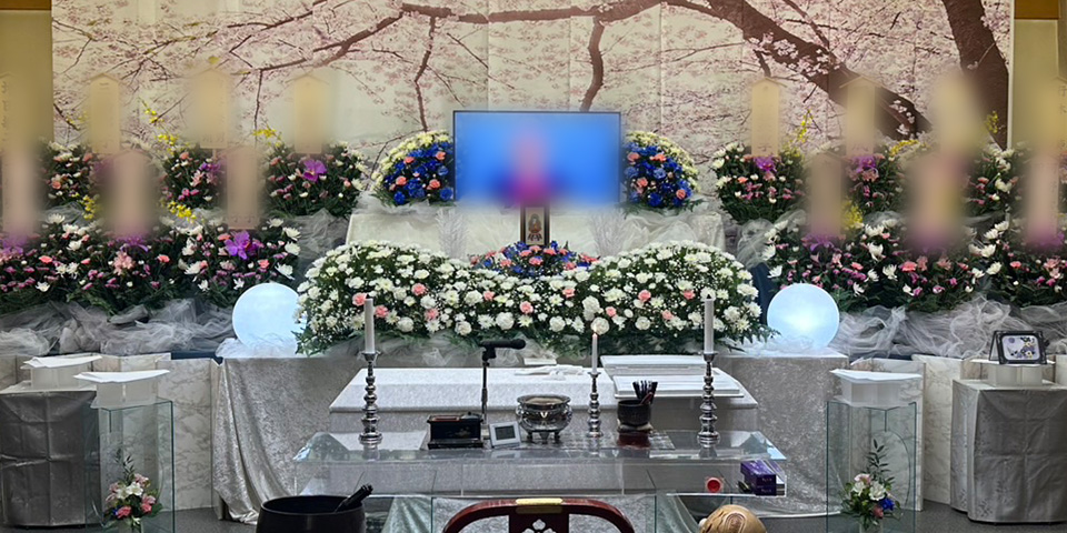 桜の屏風を背景にピンクと黄色を基調とした花の祭壇